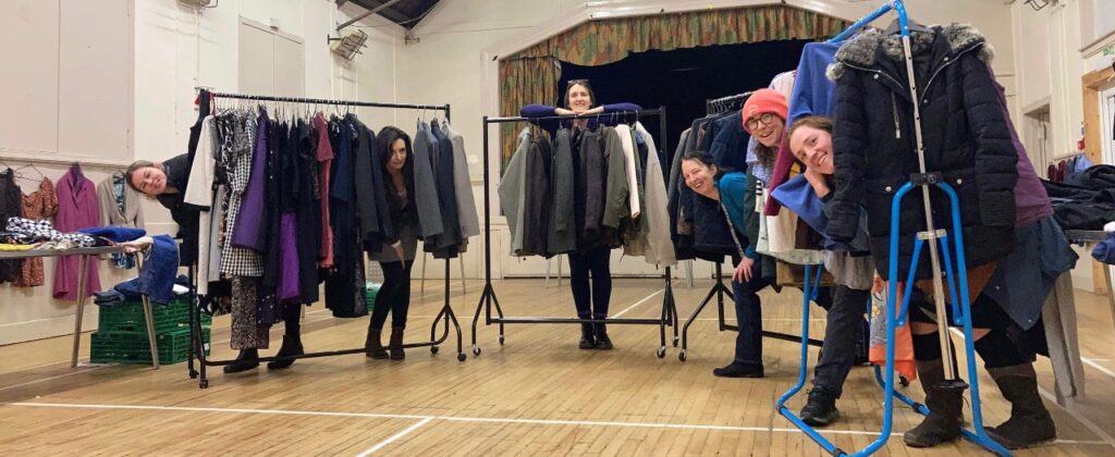 A group of women with clothes rails and clothes