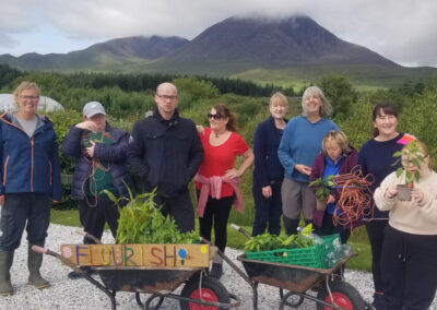 Group of people with wheelbarrows and mountains behind