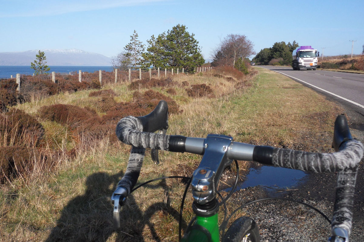 bike handlebars with sea and main road in background